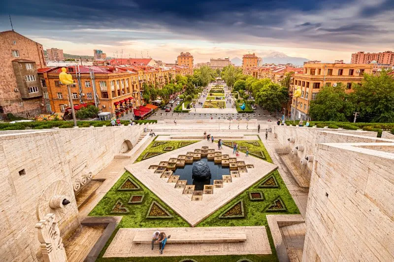 Muestra la ciudad de Ereván en Armenia. Vista panorámica desde las escaleras del monumento Cascada. En una colorida puesta de sol sobre la parte alta de la ciudad, símbolo de Armenia Monte Ararat que podrás ver al viajar a Armenia.