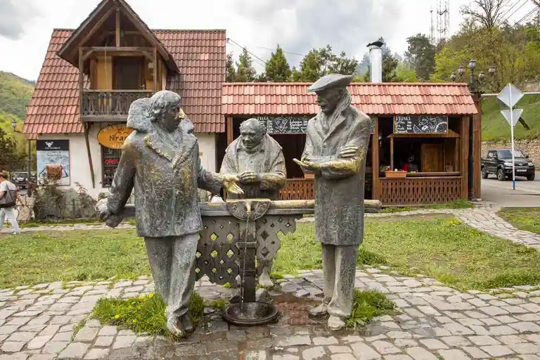 se ve 3 estatuas de bronce alrededor de una fuente en la ciudad de Dilijan de vacaciones en Armenia