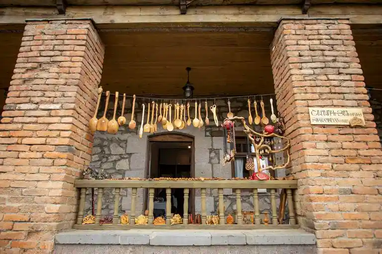 You can see a house and different cooking utensils made of wood on the terrace in the city of Dilijan on vacation in Armenia
