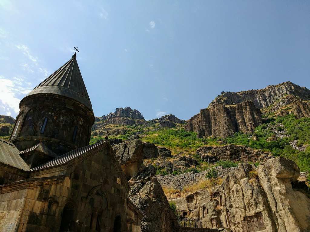 Foto realizada desde de abajo donde se muestra el monasterio de Geghard, el cielo y la montaña pegada cuando estábamos de vacaciones a Armenia